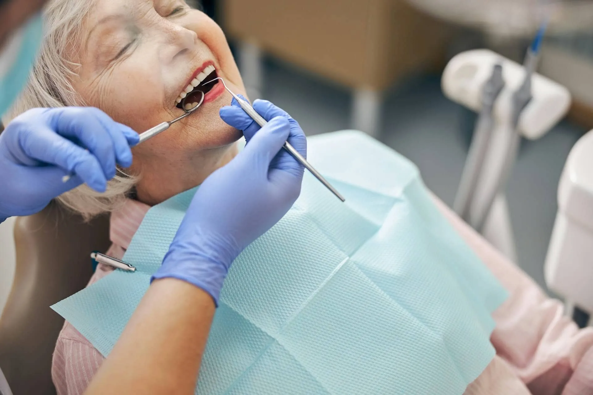 An old woman being checked by a dentist